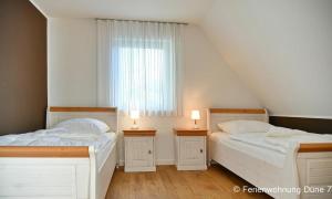 two beds in a room with a window at Düne 7 in Dierhagen