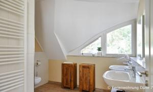 a bathroom with a sink and a window at Düne 7 in Dierhagen +13 photos