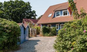 een huis met een blauw hek en een tuin bij Darßer Smuggler Hus 3 in Wieck