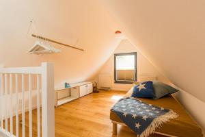 a attic bedroom with a bed and a crib at Drei Akazien Wohnung 3 in Neuhaus