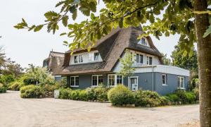 a large blue house with a thatched roof at Freischwimmer in Wieck