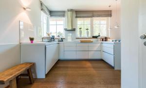 a kitchen with white cabinets and a wooden bench at Freischwimmer in Wieck