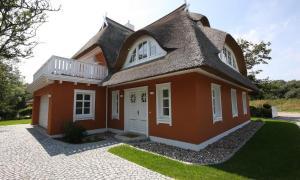 una pequeña casa roja con techo de gambrel en Strandhaus hinter der Düne, en Ahrenshoop