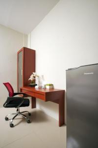 梭羅的住宿－DPARAGON SUMBER，办公室配有书桌、椅子和冰箱
