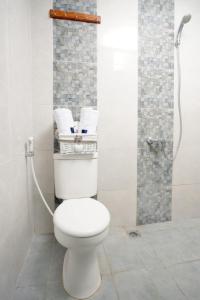 a bathroom with a white toilet and a shower at DPARAGON SUMBER in Solo