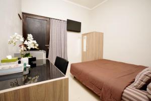 Habitación de hotel con cama y escritorio. en DPARAGON UPN, en Yogyakarta