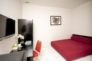 a bedroom with a red bed and a red couch at DPARAGON PRINGWULUNG in Yogyakarta