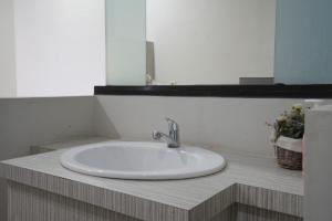 lavabo blanco en el baño con espejo en DPARAGON KALIJUDAN, en Surabaya