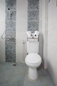W łazience znajduje się biała toaleta i prysznic. w obiekcie DPARAGON KALIJUDAN w mieście Surabaja