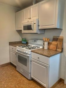 a kitchen with a stove and a microwave at Huntington Highlight - Pool, Patio, Close To Beach in Huntington Beach