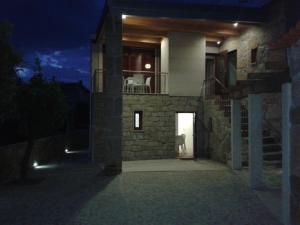 Habitación con balcón y vistas a una casa por la noche. en Casas d Aldeia Turismo Rural, en Mangualde