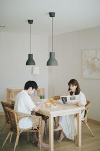 un hombre y una mujer sentados en una mesa con portátiles en Palm Crescent Hua Hin, en Cha Am