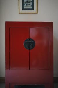 un armario rojo en una habitación con una foto en la pared en Palm Crescent Hua Hin, en Cha Am