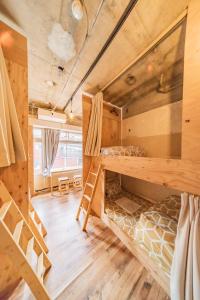 Pokój z łóżkami piętrowymi, stołem i krzesłami w obiekcie ArtBar & GuestHouse ennova w mieście Atami