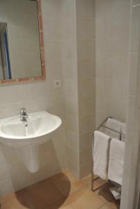 a bathroom with a sink and a mirror and towels at Hôtel Castel Mistral in Juan-les-Pins