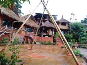 a house with a flooded yard in front of it at Akha Mud House Mae Salong in Mae Salong