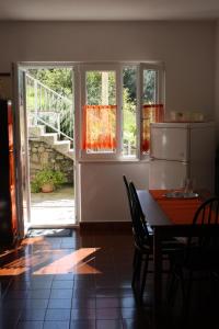 a kitchen with a table and chairs and a sliding glass door at Apartment Nikola in Dubrovnik