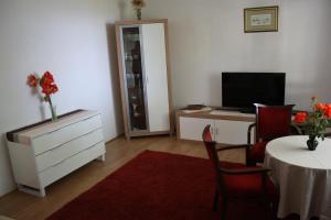 a living room with a dresser and a table with a television at Apartment Nikola in Dubrovnik