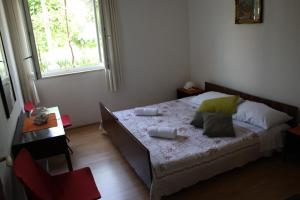 a bedroom with a bed and a table and a window at Apartment Nikola in Dubrovnik