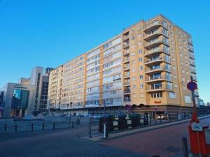 un grand bâtiment sur le côté d'une rue dans l'établissement Scarphout genieten aan zee, à Blankenberge