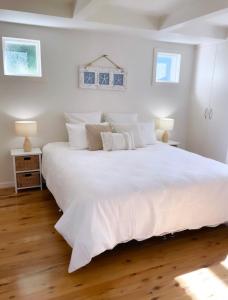 a bedroom with a large white bed with white pillows at Little Hacienda - Port Lincoln in Port Lincoln