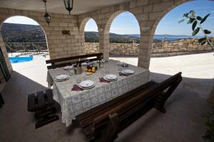 einen Tisch in einem Steingebäude mit einem Tisch und Stühlen in der Unterkunft Villa Monica in Ložišće