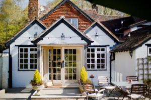 a white house with a table and chairs at The Old House Inn in Burstow