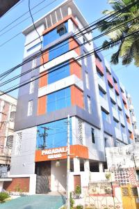 un edificio alto con naranja y blanco en Pagadala Grand Residency en Bāpatla
