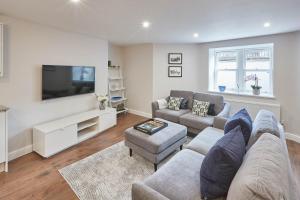 a living room with a couch and a tv at Host & Stay - The Garden Apartment in Harrogate