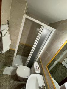 uma casa de banho com um WC e uma cabina de duche em vidro. em H Arkanta em Arganda del Rey