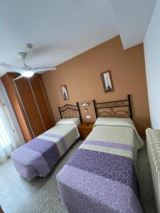 een slaapkamer met 2 bedden en een plafond bij H Arkanta in Arganda del Rey