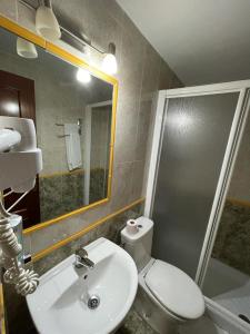 a bathroom with a toilet and a sink and a shower at H Arkanta in Arganda del Rey