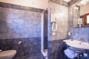 e bagno con servizi igienici, lavandino e doccia. di Suvaki Resort a Pantelleria