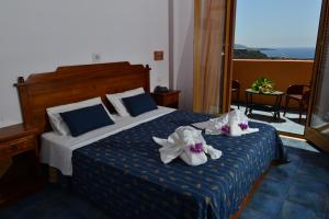 a hotel room with a bed with towels on it at Suvaki Resort in Pantelleria