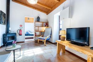 a living room with a large television and a fireplace at Cottage in historical town of Aljezur in Aljezur