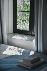 a window in a room with a bed and a window sill at Atelier Boutique Hotel in Shkodër