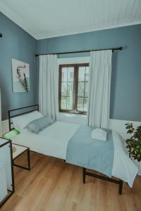 1 dormitorio con 2 camas y ventana en Atelier Boutique Hotel en Shkodër