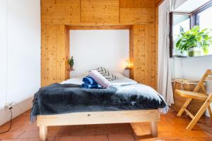 a bedroom with a bed with a black blanket at Cottage in historical town of Aljezur in Aljezur