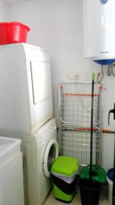 uma cozinha com uma máquina de lavar roupa e um banco verde em Sueño de Denia III VAC007 Denirent em Denia