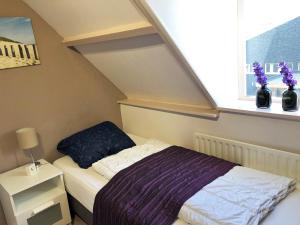 een kleine slaapkamer met een bed en een raam bij Casa Sea 2 personen en Casa Beach 4 personen in Westkapelle