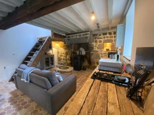 een woonkamer met een bank en een stenen open haard bij Domaine Des Tours Vauquelin in La Fresnaye-au-Sauvage