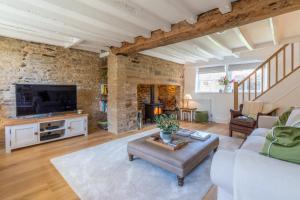 a living room with a couch and a tv at Tachbrook in Charlbury