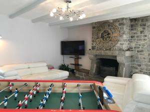 a living room with a ping pong table and a fireplace at Gîte de la Motte in Quettreville-sur-Sienne