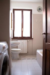 łazienka z toaletą, oknem i umywalką w obiekcie PANORAMA - Apartment with terrace overlooking the Lake w mieście Massino Visconti