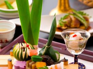 a table with a plate of food and a wine glass at Ryotei Tanokura in Yufu