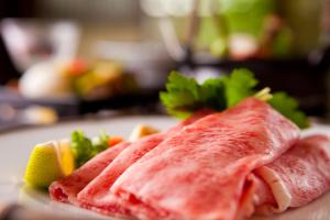 dos trozos de salmón sentados en un plato con verduras en Ryotei Tanokura, en Yufu