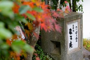 a stone bird house with chinese writing on it at Ryotei Tanokura in Yufuin