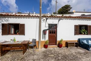une terrasse avec une table et des chaises en bois devant une maison dans l'établissement Cottage in historical town of Aljezur, à Aljezur