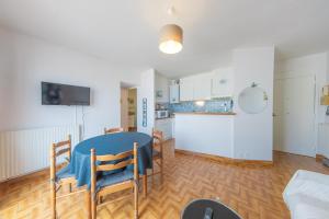 a kitchen and dining room with a blue table and chairs at Résidence Clemenceau 1 in Royan