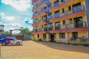 a building with a car parked in front of it at Harts Motel in Kampala